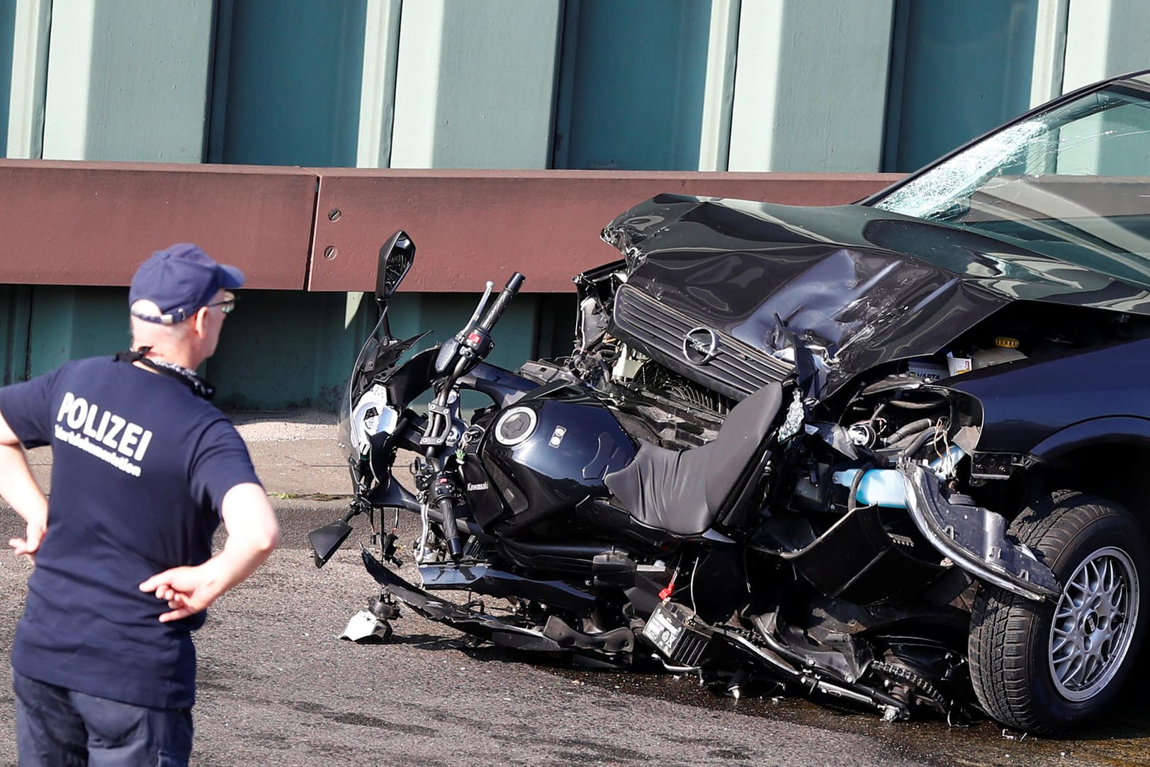 Polizeibeamter mit dem Wrack des Fahrzeugs: Auf der Berliner Stadtautobahn hat ein Mann mutmaßlich versucht, einen islamistisch motivierten Anschlag zu verüben.