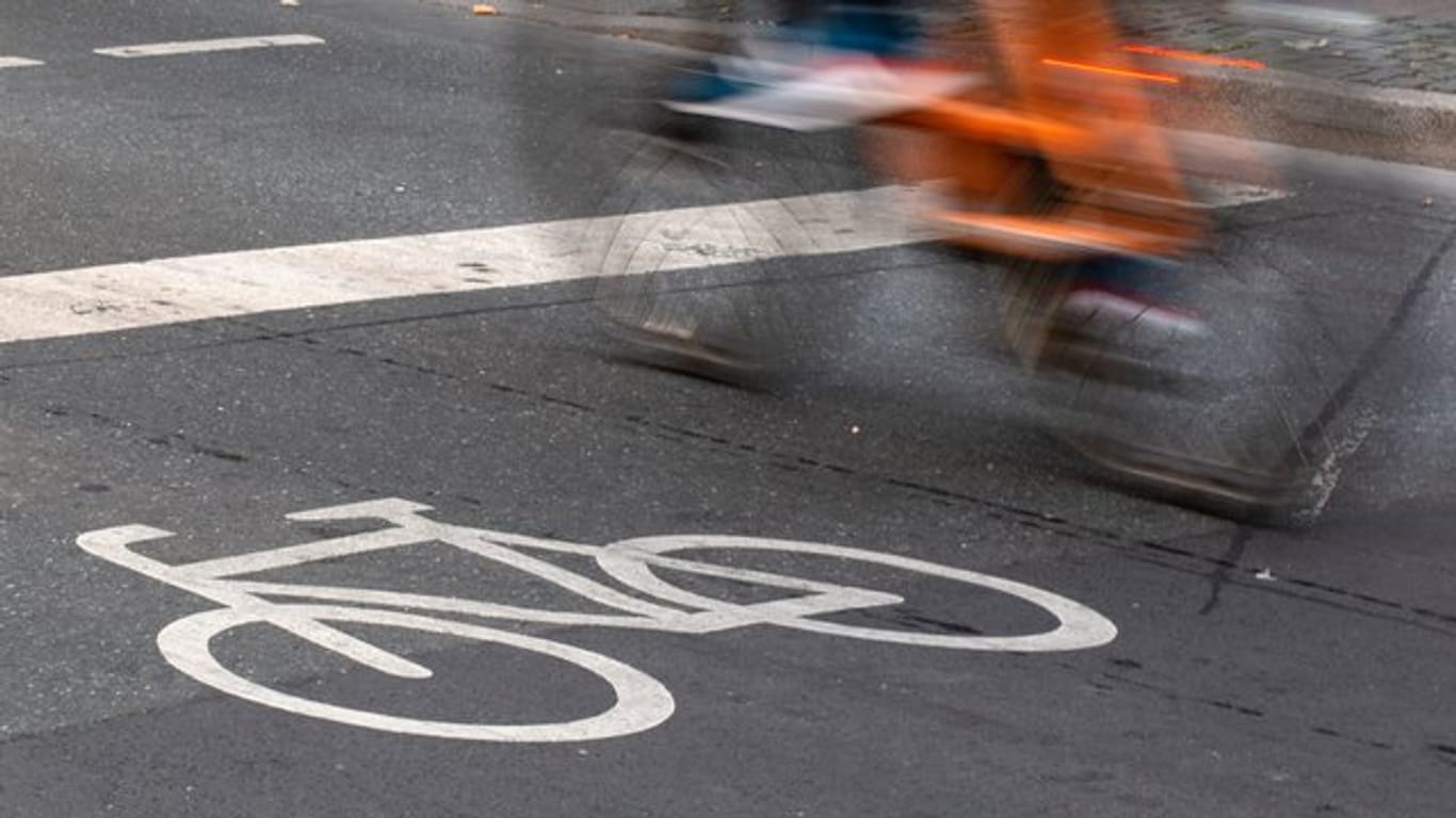 Ein Fahrradfahrer fährt in der Innenstadt über einen Radweg.