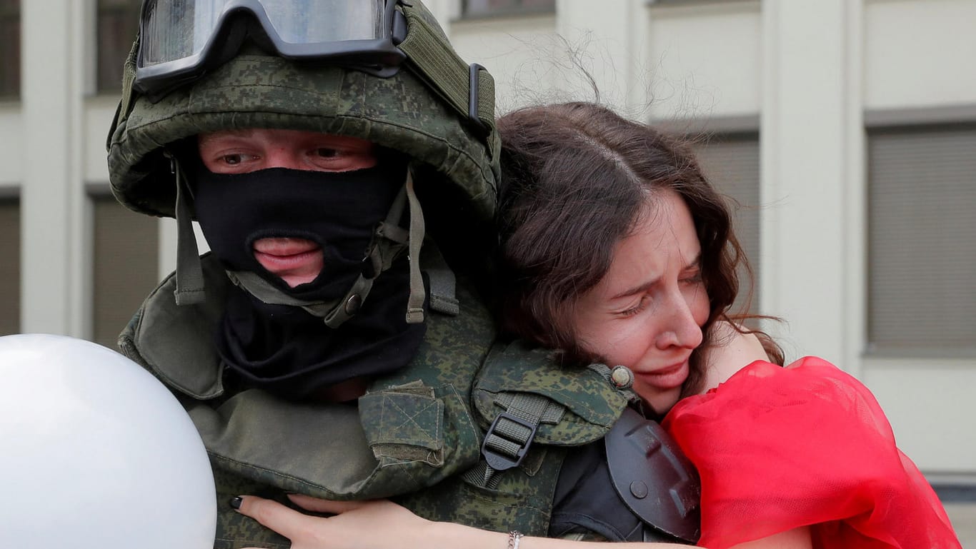 Proteste in Minsk: Eine Demonstrantin umarmt einen Sicherheitsbeamten.