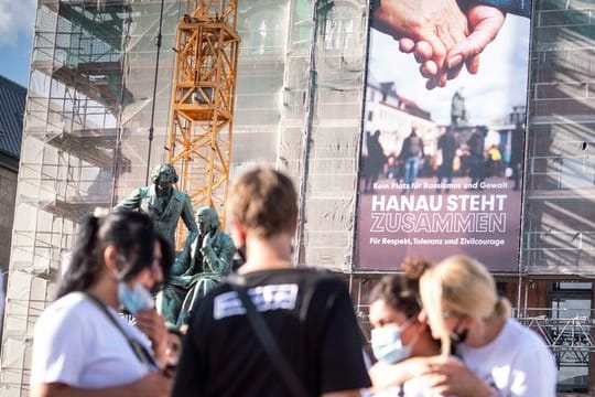 Ein neues Banner mit der Aufschrift "Kein Platz für Rassismus und Gewalt - Hanau steht zusammen für Respekt, Toleranz und Zivilcourage" hängt an der Fassade des Rathauses vor dem Gebrüder-Grimm-Denkmal.