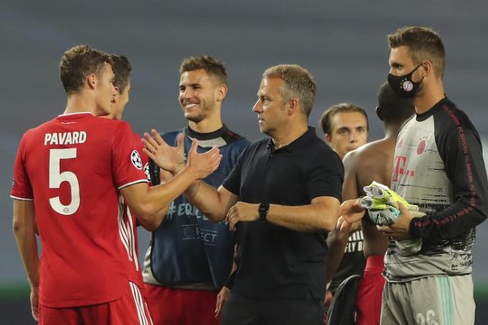 Bayern-Trainer Hans-Dieter Flick (M) gratuliert seinen Spielern zum Sieg gegen Olympique Lyon.
