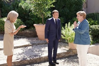 Emmanuel Macron und seine Frau Brigitte (l) begrüßen Bundeskanzlerin Angela Merkel bei ihrer Ankunft in der Sommerresidenz Macrons.