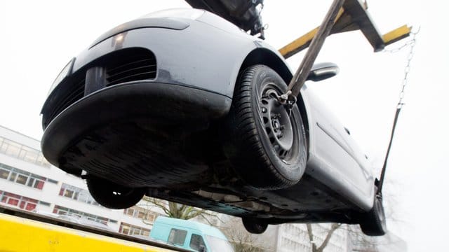 Ein Auto wird auf einen Abschleppwagen gehoben. Ein Auto wird auf einen Abschleppwagen gehoben.