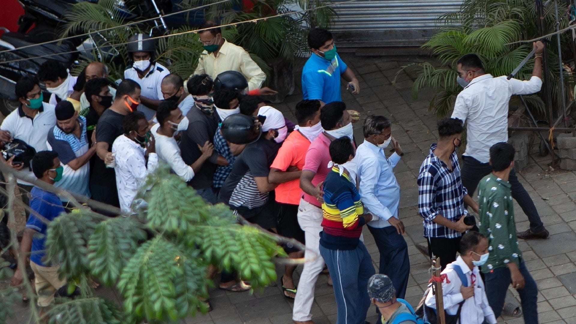 Indien, Mumbai: Ein Polizist in Zivil holt mit einem Schlagstock gegen die in einer Warteschlange stehenden Kunden eines Alkoholika-Ladens aus. Sie haben nicht den nötigen Abstand zueinander eingehalten.