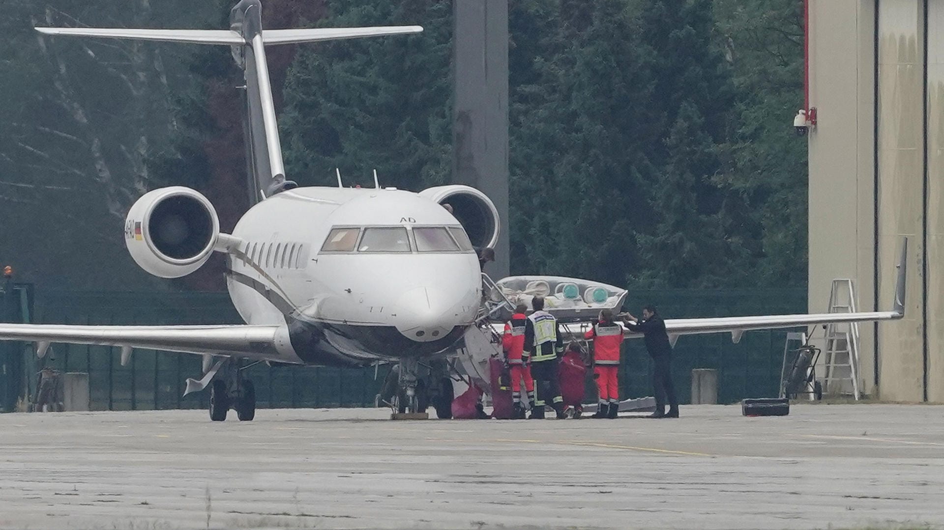 Ein Spezialflugzeug mit dem Kremlkritiker Nawalny an Bord steht auf dem Flughafen Tegel vor einem Hangar. Eine Trage wird aus den Flieger gehoben.