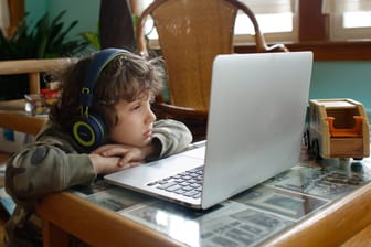 Ein Junge vor einem Laptop: In England hat ein Kind einen Riesentruck für 19.000 Pfund ersteigert