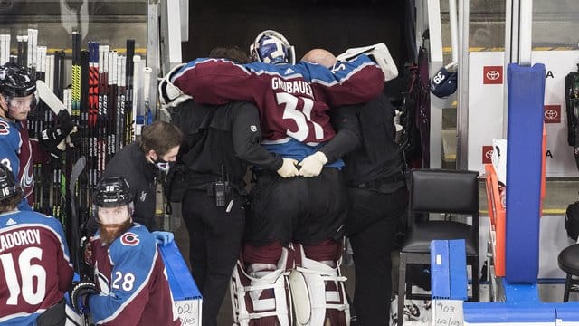 Dem verletzten Torhüter Philipp Grubauer (M) von den Colorado Avalanche wird in die Umkleidekabine geholfen. Dem verletzten Torhüter Philipp Grubauer (M) von den Colorado Avalanche wird in die Umkleidekabine geholfen.
