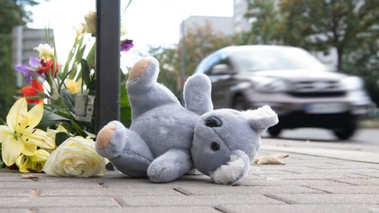 Ein Plüschtier und Blumen liegen nach dem schweren Verkehrsunfall am Unfallort in Dresden.