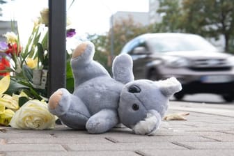Ein Plüschtier und Blumen liegen nach dem schweren Verkehrsunfall am Unfallort in Dresden.