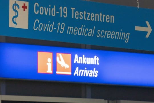 Ein Schild weist am Frankfurter Flughafen den Weg zum Covid-19-Testzentrum.