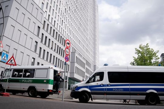 Mannschaftswagen der Berliner Polizei stehen vor der Charité.