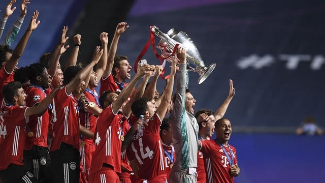 Bayerns Torhüter Manuel Neuer stemmt die Trophäe in die Höhe und jubelt mit dem Team.