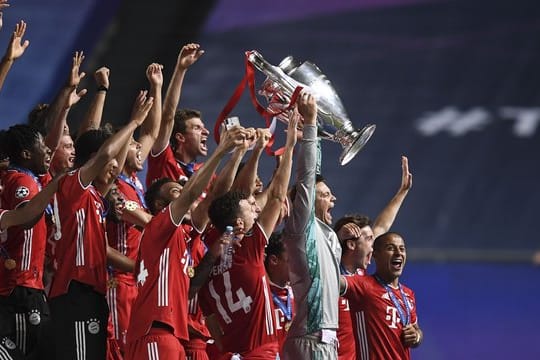 Bayerns Torhüter Manuel Neuer stemmt die Trophäe in die Höhe und jubelt mit dem Team.