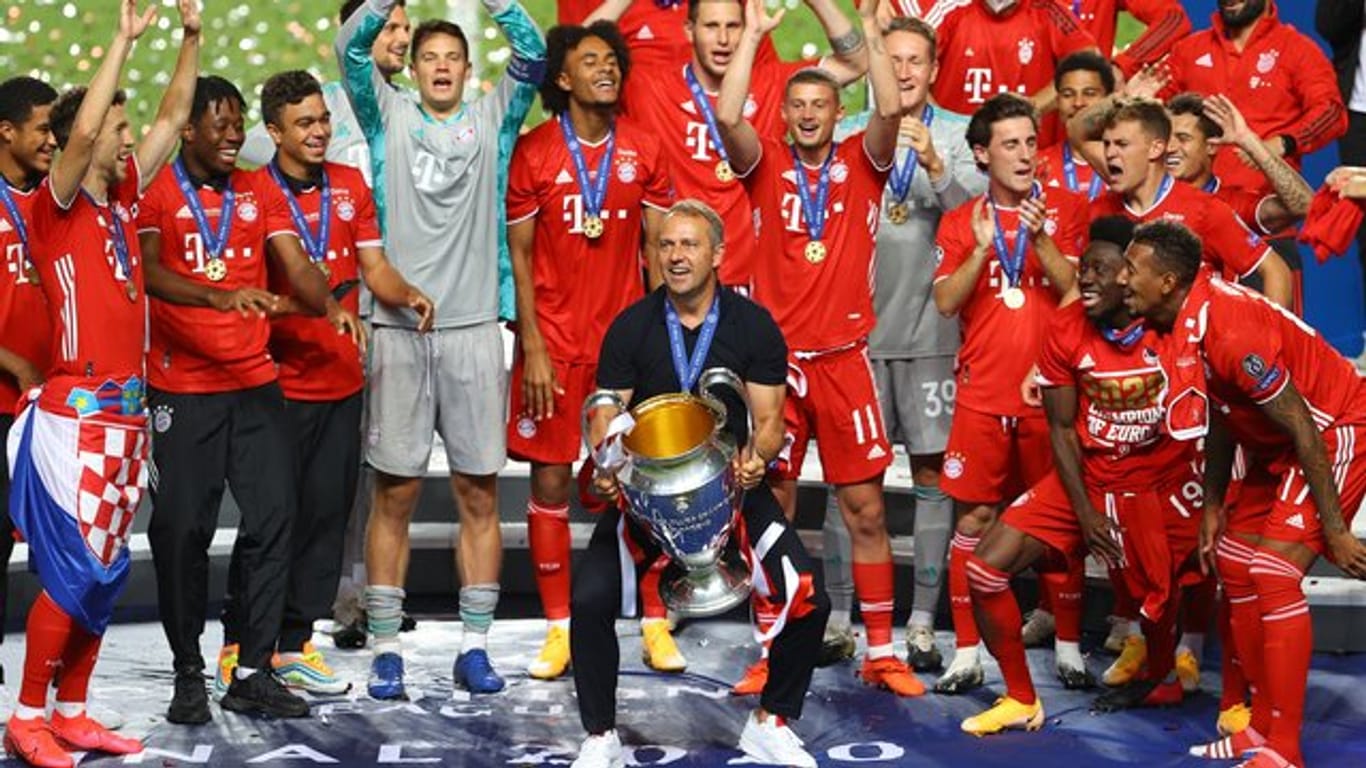 Hat mit dem FC Bayern München das Triple geschafft: Cheftrainer Hans-Dieter Flick (M) bei der Siegerehrung.