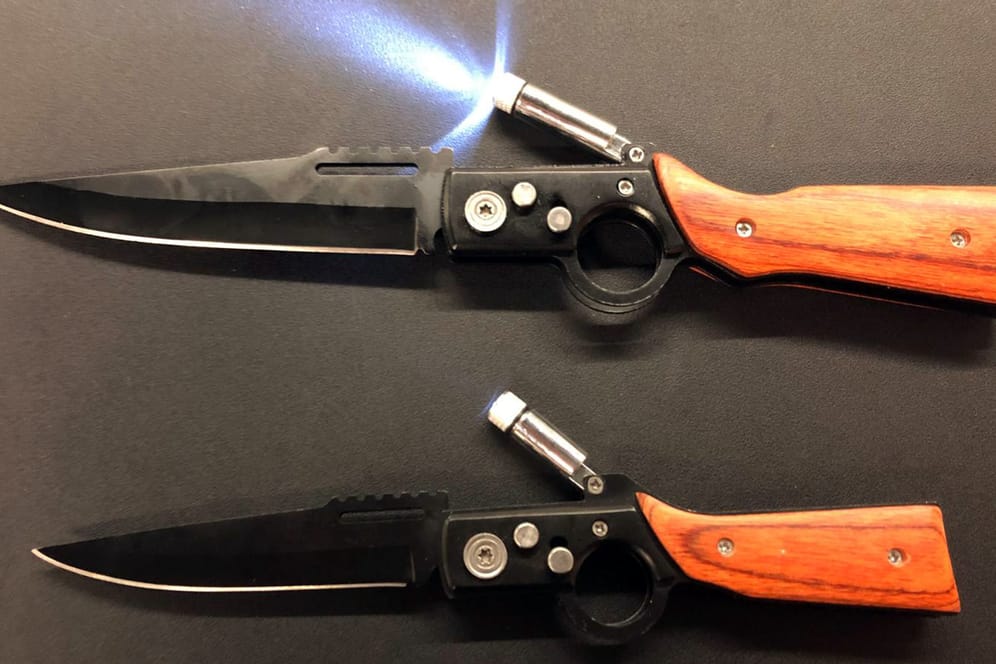 Zwei Springmesser, deren Form an Schusswaffen erinnert, liegen auf einem Tisch: Diese verbotenen Gegenstände wollte ein Mann am Flughafen Düsseldorf ins Land schmuggeln.