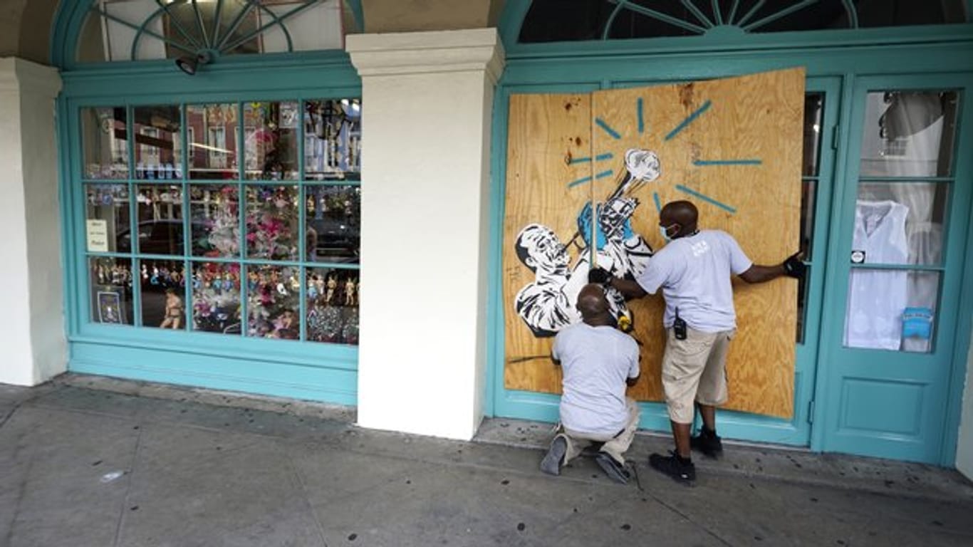 Arbeiter vernageln in Vorbereitung auf Sturm "Marco" die Scheiben eines Geschäfts in New Orleans.