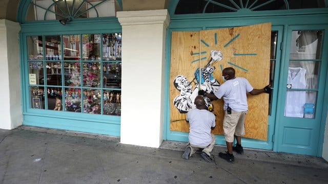Arbeiter vernageln in Vorbereitung auf Sturm "Marco" die Scheiben eines Geschäfts in New Orleans. Arbeiter vernageln in Vorbereitung auf Sturm "Marco" die Scheiben eines Geschäfts in New Orleans.