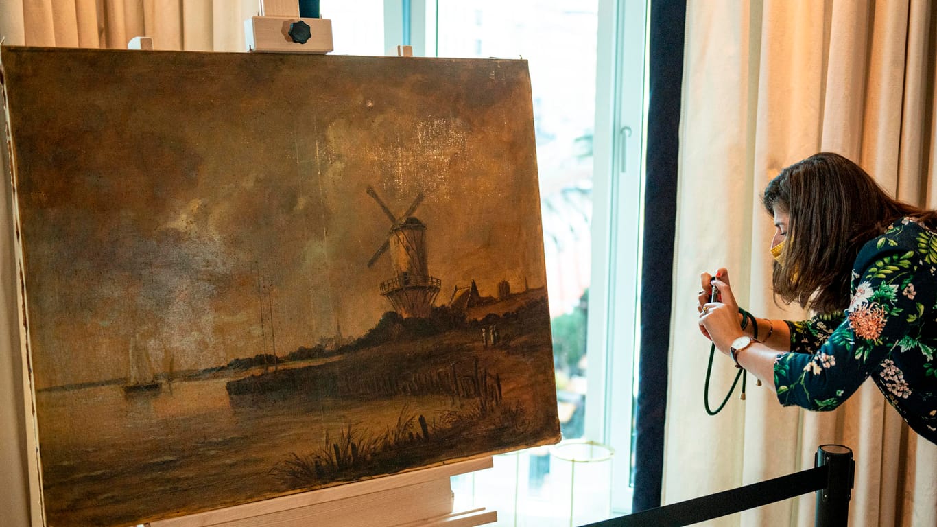 Eine Frau fotografiert das in seiner Echtheit umstrittene Van-Gogh-Gemälde, welches vom Auktionshaus Dechow in Hamburg versteigert werden soll. Das Mindestgebot für das Gemälde mit dem Titel "Die Mühle von Wijk" liegt bei 500.000 Euro.