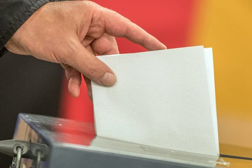 Ein Wähler wirft seinen Stimmzettel zur Bundestagswahl in die Wahlurne.