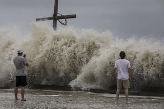 Mark Allums (l) und Hunter Clark fotografieren in HIgh Island, Texas, die hohen Wellen, die als Vorboten von Hurrikan "Laura" auf die Küste treffen.