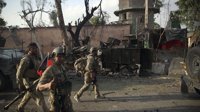 Afghanische Sicherheitskräfte versammeln sich nach einem Angriff vor einem Gefängnis. Afghanische Sicherheitskräfte versammeln sich nach einem Angriff vor einem Gefängnis.
