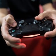 Ein Gamer spielt mit einer PlayStation 4: Die Nutzer von Computer- und Videospielen verbringen seit dem Ausbruch der Coronakrise deutlich mehr Zeit an der Spielekonsole oder anderen Gaming-Geräten.