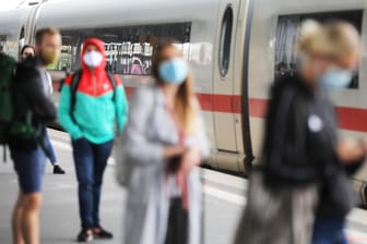 Bahnreisende warten mit Mund-Nasen-Schutz auf ihren Zug: Die Deutsche Bahn will die Maskenkontrollen im September ausweiten.