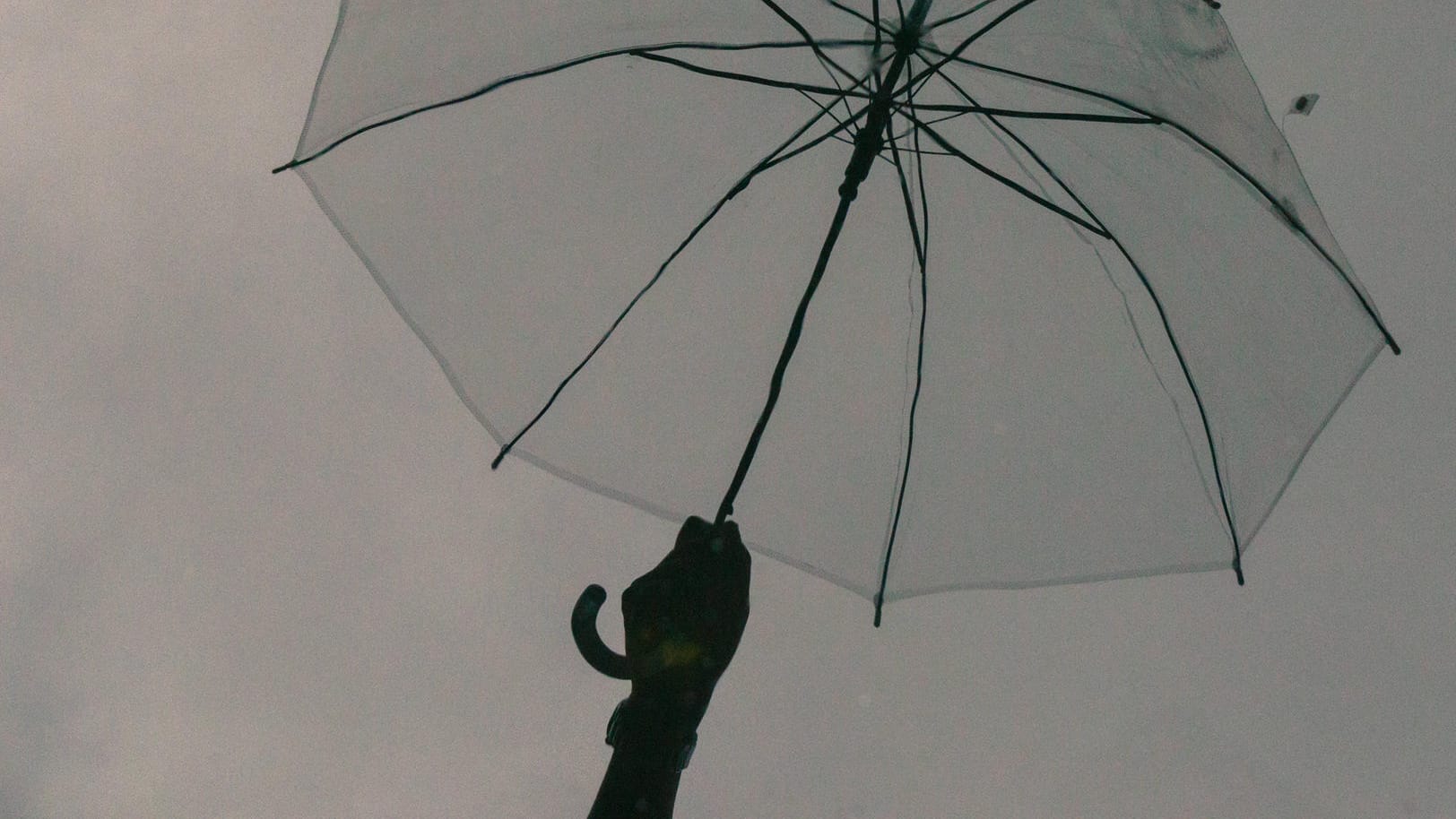 Ein Regenschirm vor einem grauen Himmel (Symbolbild): In Dortmund wird es stürmisch.