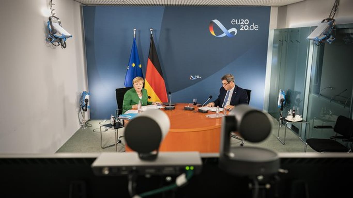 Bundeskanzlerin Angela Merkel (l) und Markus Söder bei der Videokonferenz mit Länderregierungschefs.