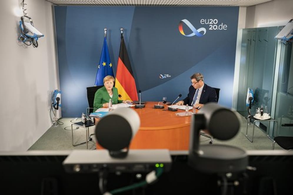 Bundeskanzlerin Angela Merkel (l) und Markus Söder bei der Videokonferenz mit Länderregierungschefs.