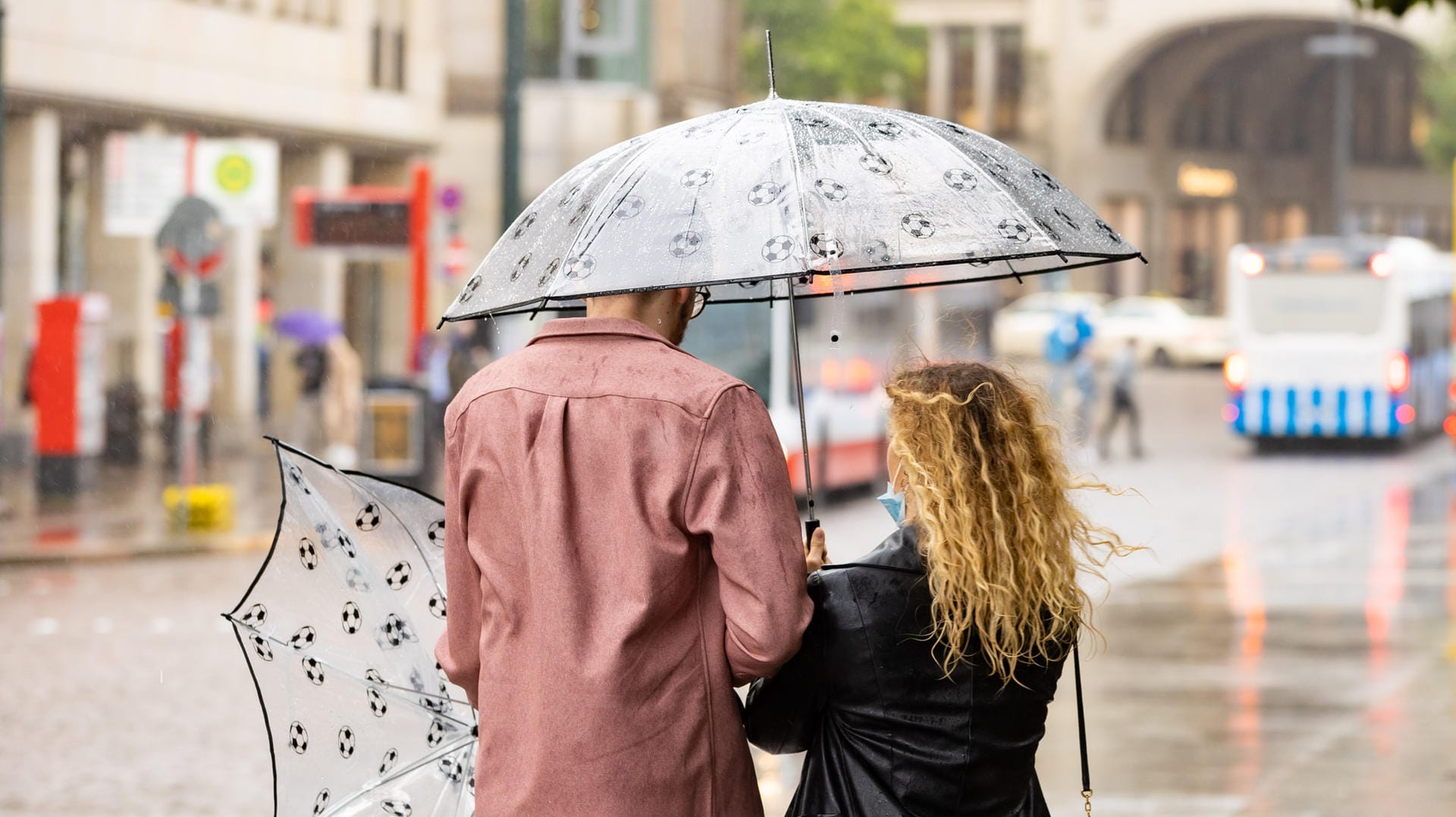 Mit Regenschirmen schützt sich ein Paar vor dem Regenwetter: Auch in den kommenden Tagen bleibt das Wetter in Norddeutschland unbeständig.