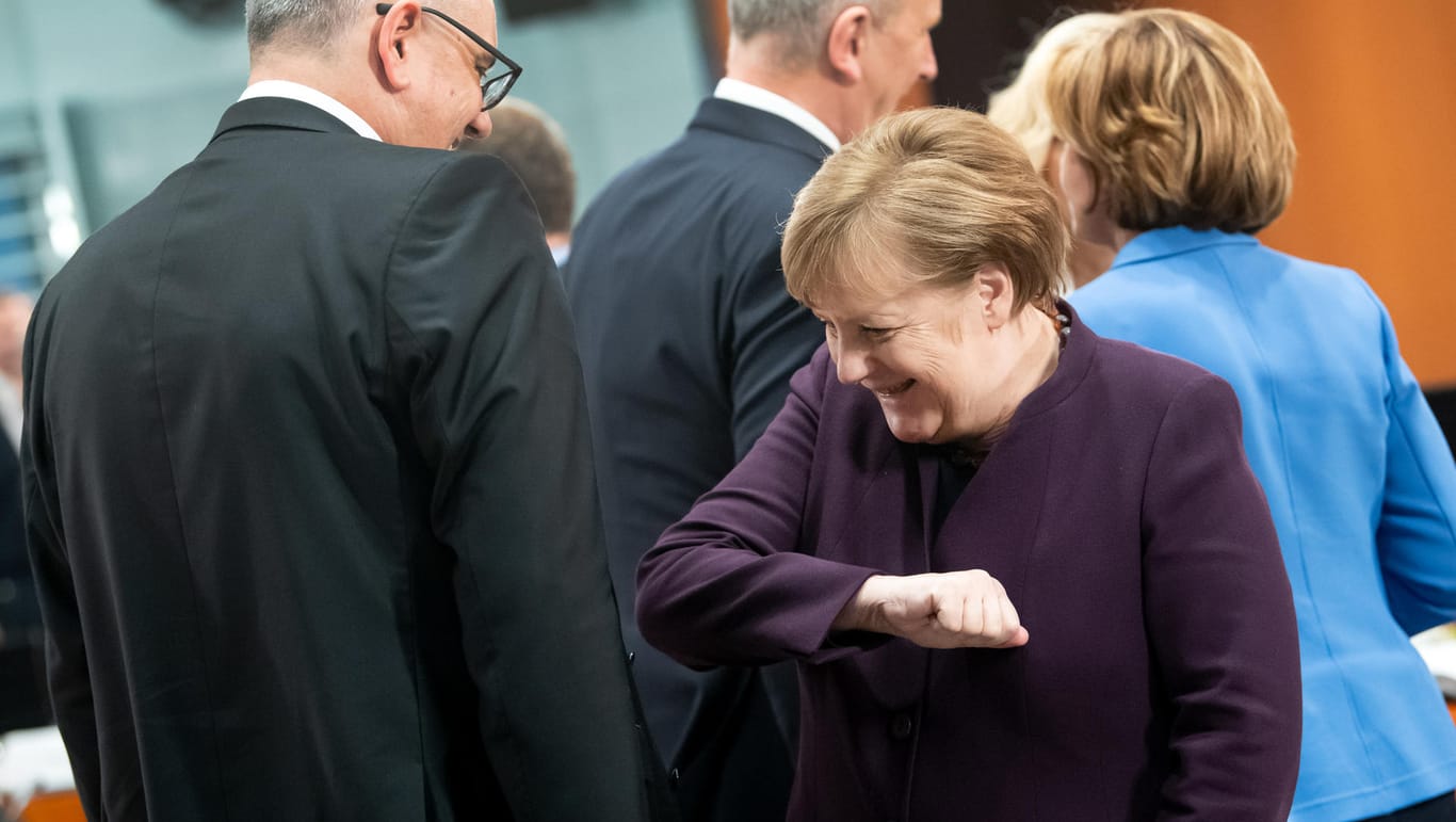 Bundeskanzlerin Angela Merkel (CDU) und Peter Tschentscher (SPD): Beim Treffen der Bundeskanzlerin und weiteren Mitgliedern der Bundesregierung begrüßen sich die beiden mit dem sogenannten "Ebola-Gruß".