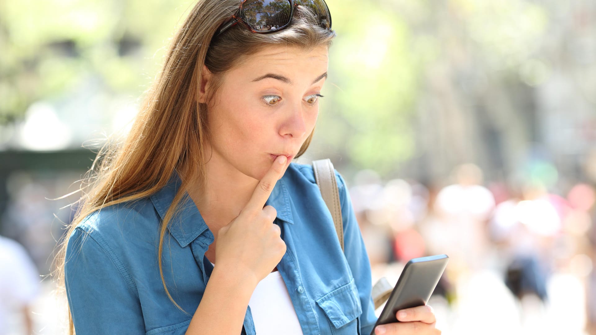 Eine Frau erschrickt beim Blick auf ihr Smartphone: Wir erklären, wie Sie peinliche WhatsApp-Nachrichten nachträglich löschen können.