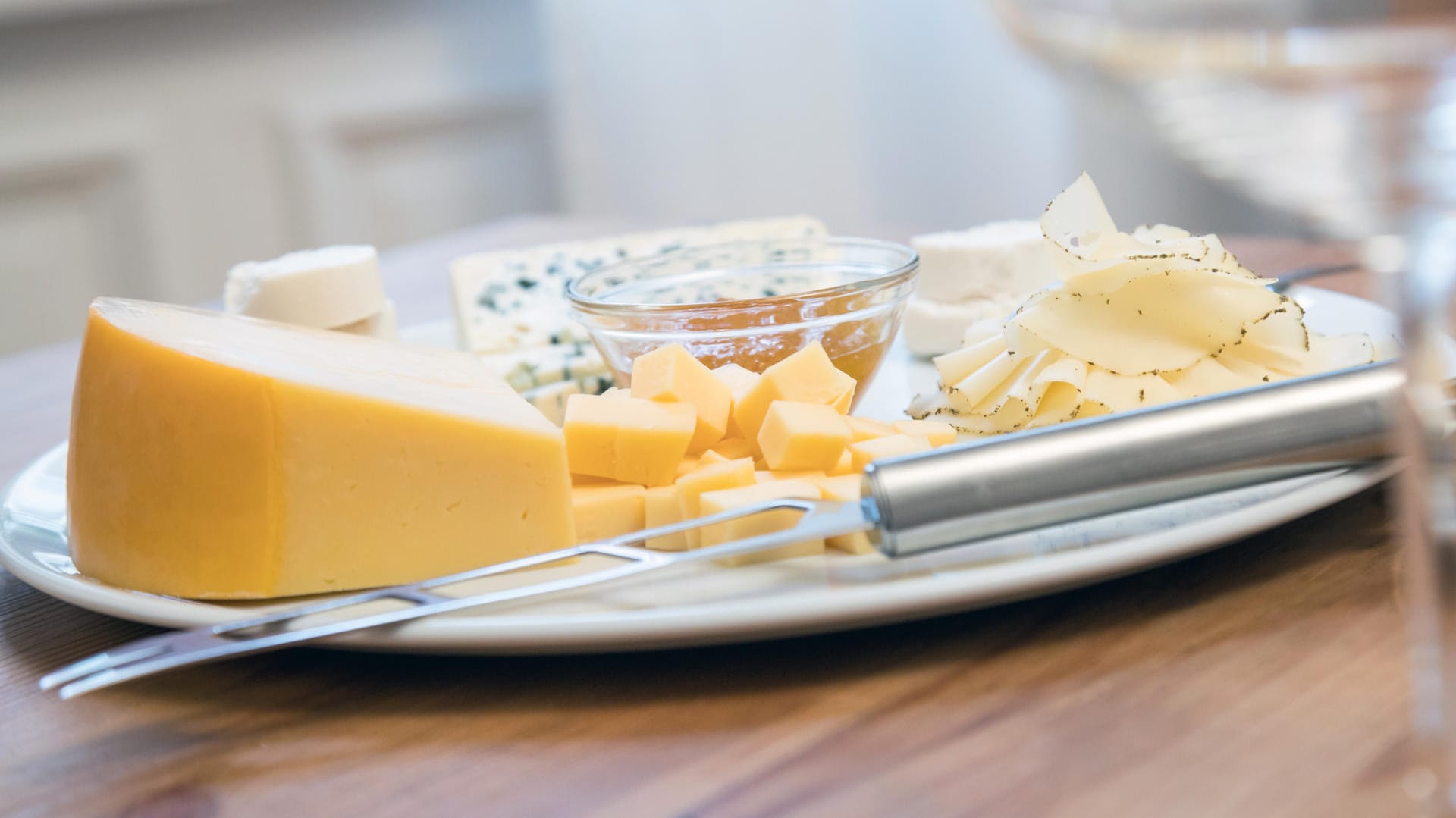 Verschiedene Käsesorten auf einem Teller: Bei einigen Supermarktketten werden die Preise für Käse gesenkt.