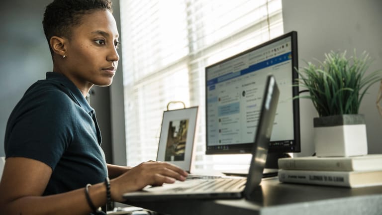 Eine junge Frau arbeitet zu Hause am Laptop (Symbolbild): Um ein Arbeitszimmer von der Steuer absetzen zu können, muss man strenge Vorgaben erfüllen.