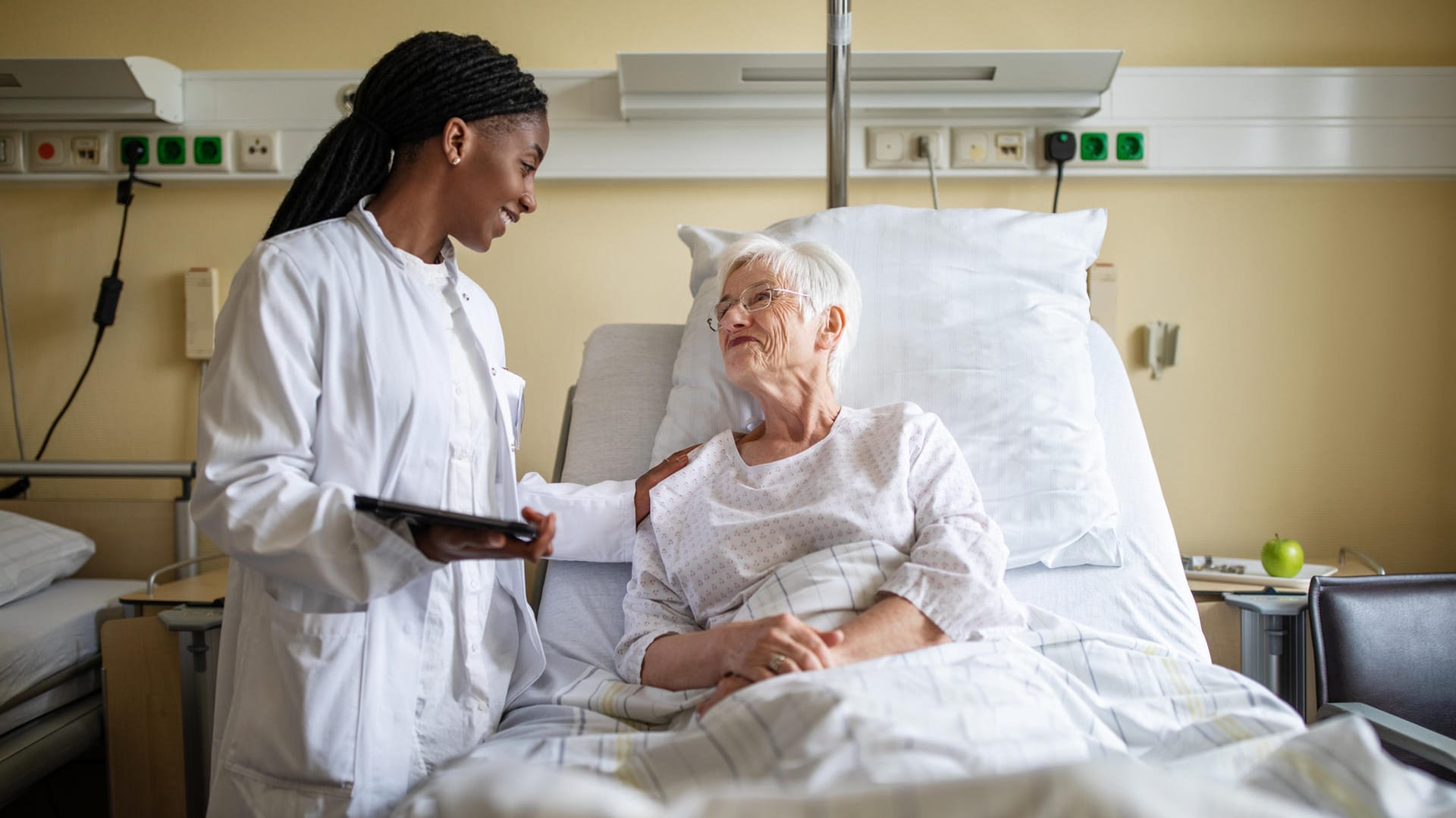 Eine Ärztin spricht mit einer Patientin (Archivbild): Für ein Einzel- oder Zweibettzimmer muss man im Krankenhaus draufzahlen. Eine Krankenhauszusatzversicherung kann hier helfen.