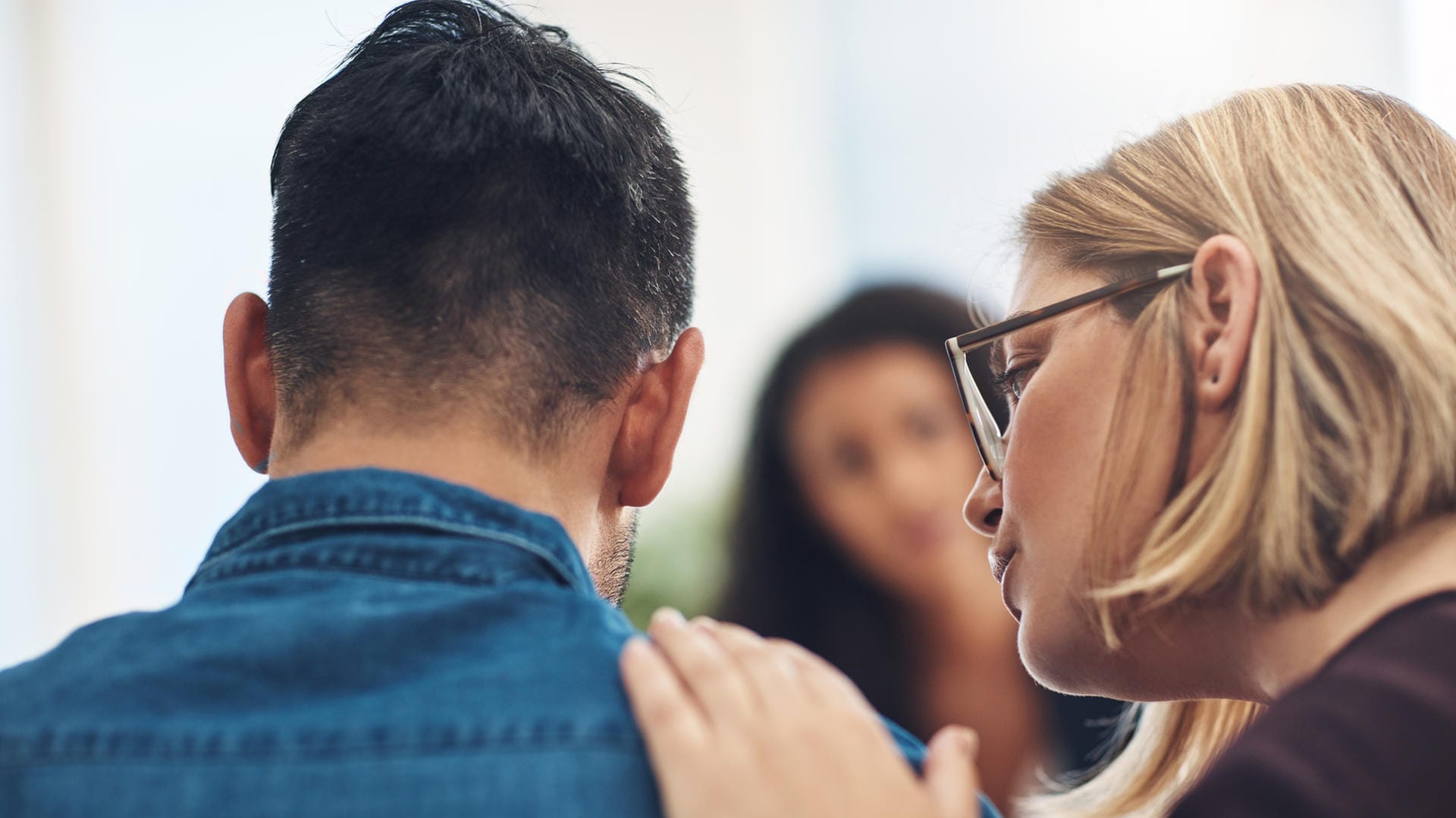 Eine Frau tröstet einen Mann. Wenn ein Familienmitglied an einer Depression erkrankt ist, kann professionelle Hilfe sinnvoll sein.