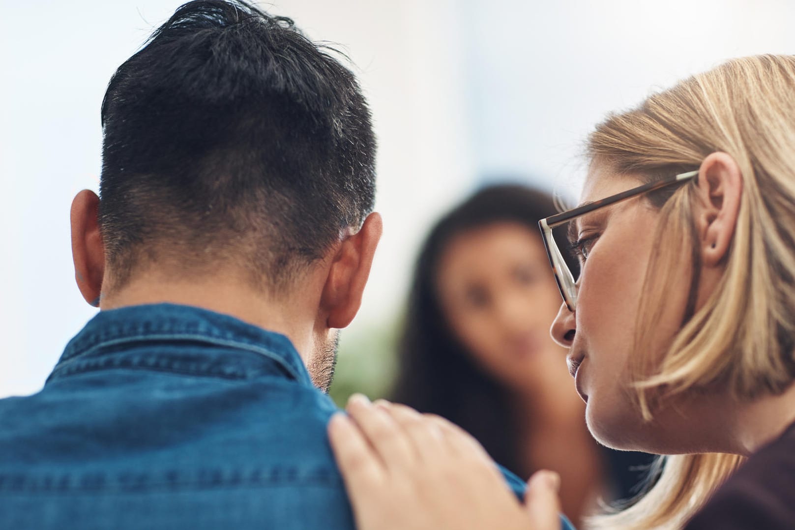 Eine Frau tröstet einen Mann. Wenn ein Familienmitglied an einer Depression erkrankt ist, kann professionelle Hilfe sinnvoll sein.