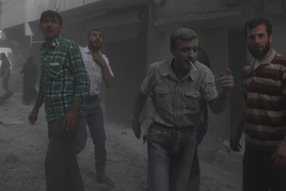 Bürgerkrieg in Syrien: Zivilisten stehen nach einem Luftangriff auf der Straße.
