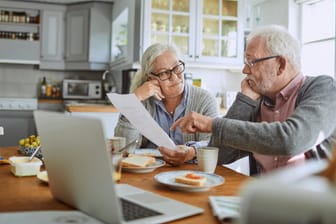 Ein älteres Paar prüft einen Vertrag (Symbolbild): Wer seine Riester-Rente kündigt, muss mit Verlusten rechnen.