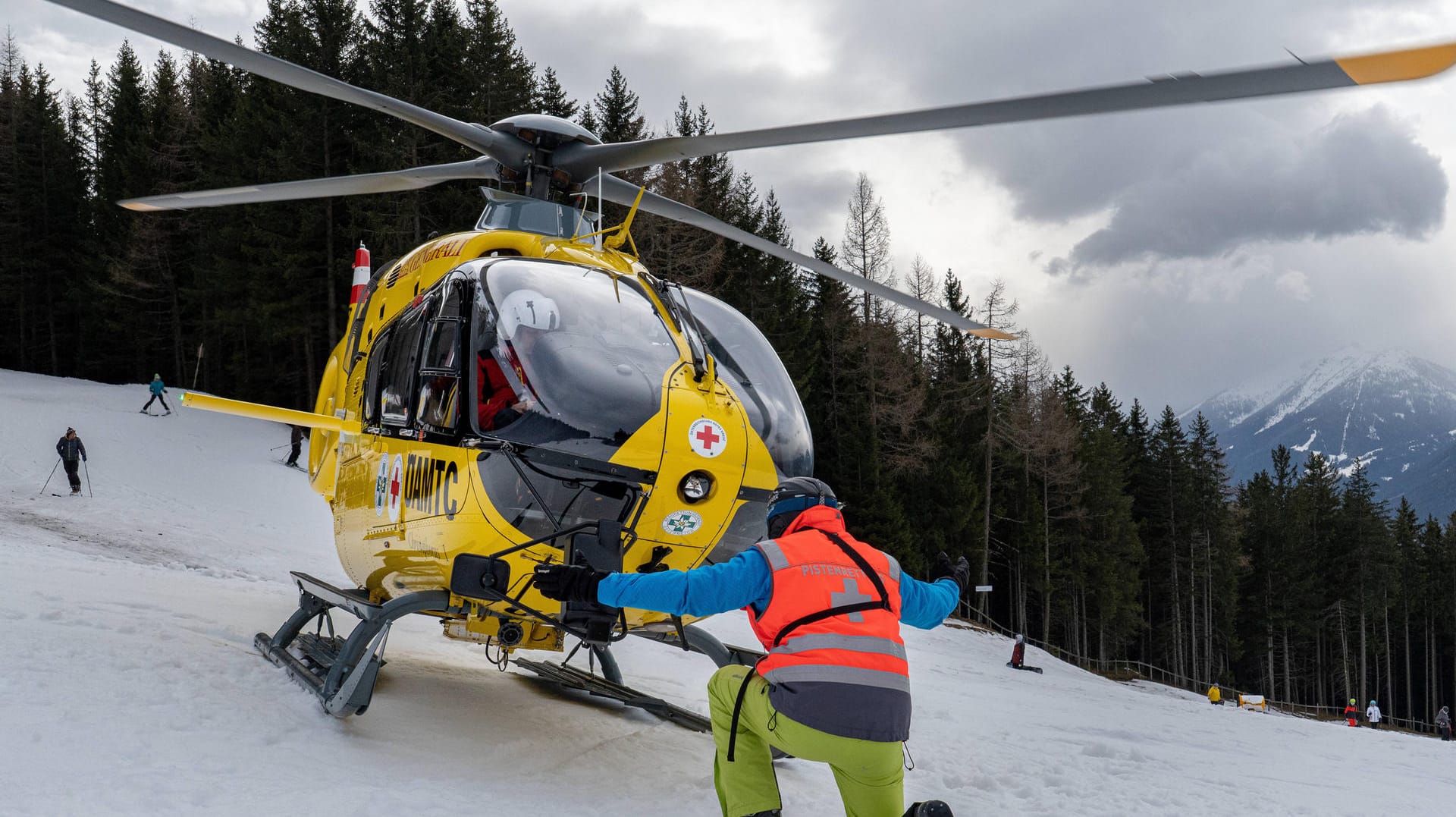 Rettungshubschrauber landet auf einer Skipiste (Symbolbild): Besonders bei risikoreichen Urlauben sollten Sie eine Auslandskrankenversicherung abschließen.