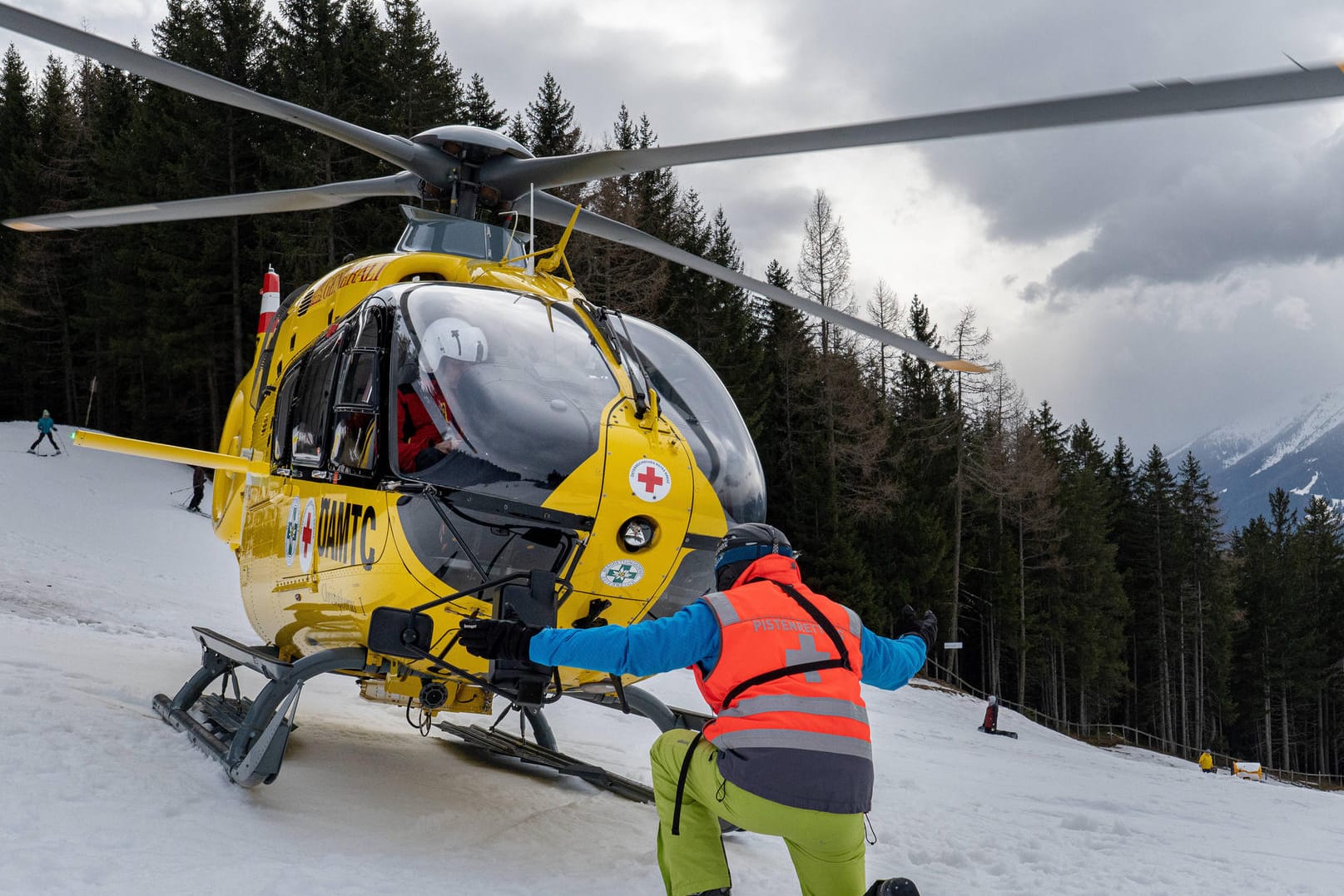 Rettungshubschrauber landet auf einer Skipiste (Symbolbild): Besonders bei risikoreichen Urlauben sollten Sie eine Auslandskrankenversicherung abschließen.