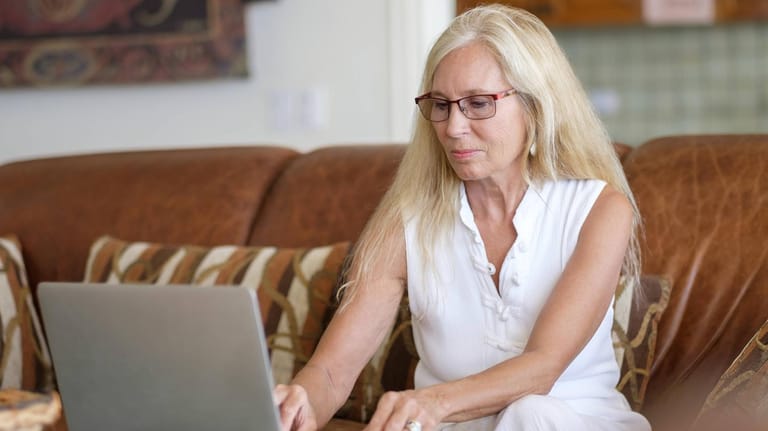 Ältere Frau sitzt am Laptop (Symbolbild): Die Direktversicherung zu kündigen ist eine komplizierte Angelegenheit.