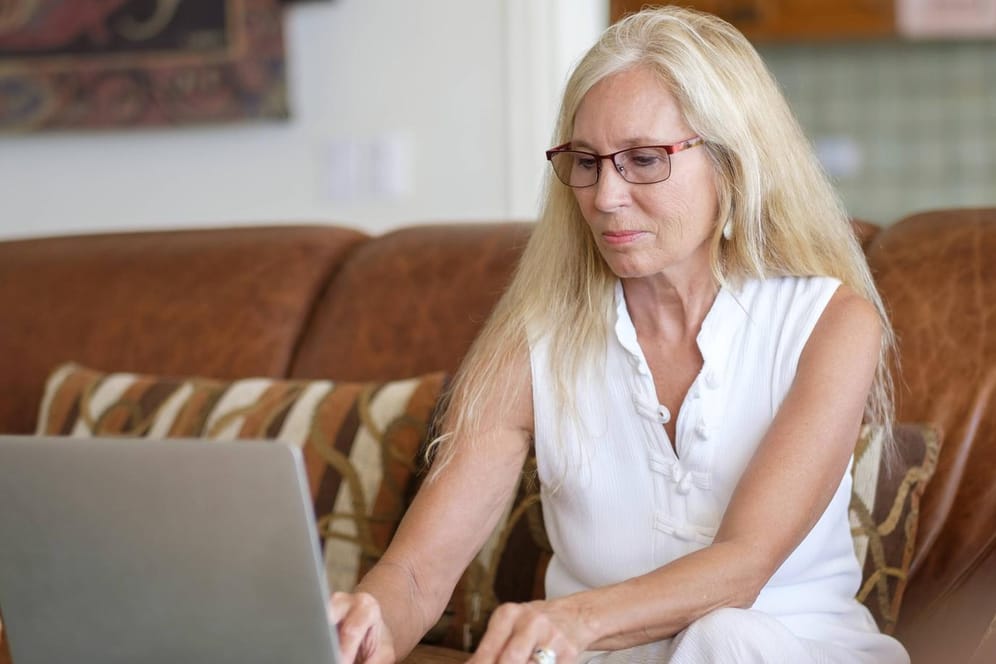 Ältere Frau sitzt am Laptop (Symbolbild): Die Direktversicherung zu kündigen ist eine komplizierte Angelegenheit.