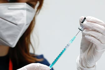 Eine Helferin im Impfzentrum zieht eine Spritze mit Impfstoff auf (Symbolbild). Das RKI hat neue Zahlen zu Neuinfektionen vorgelegt.
