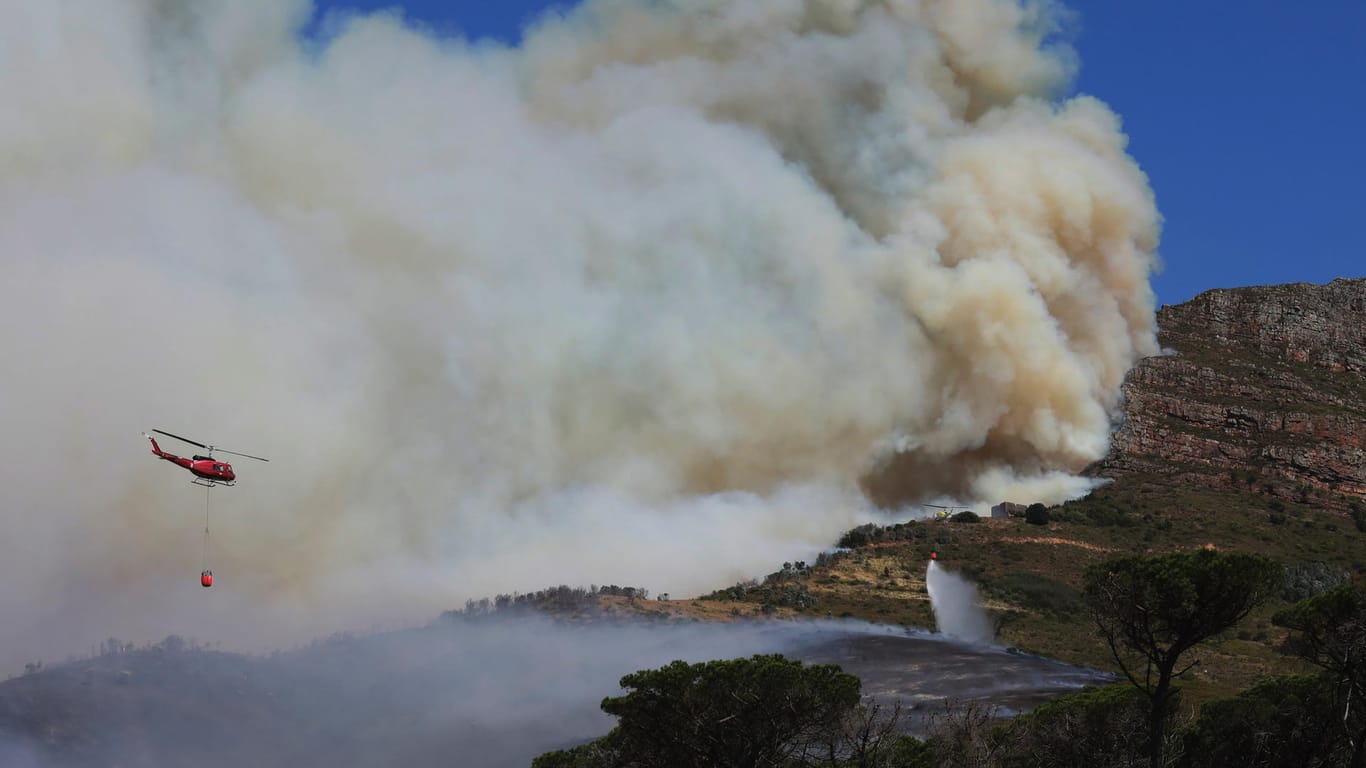 Dichte Rauchschwaden stehen über den Hängen des Tafelberg. Große Flächen des Wahrzeichens von Kapstadt sind verbrannt.