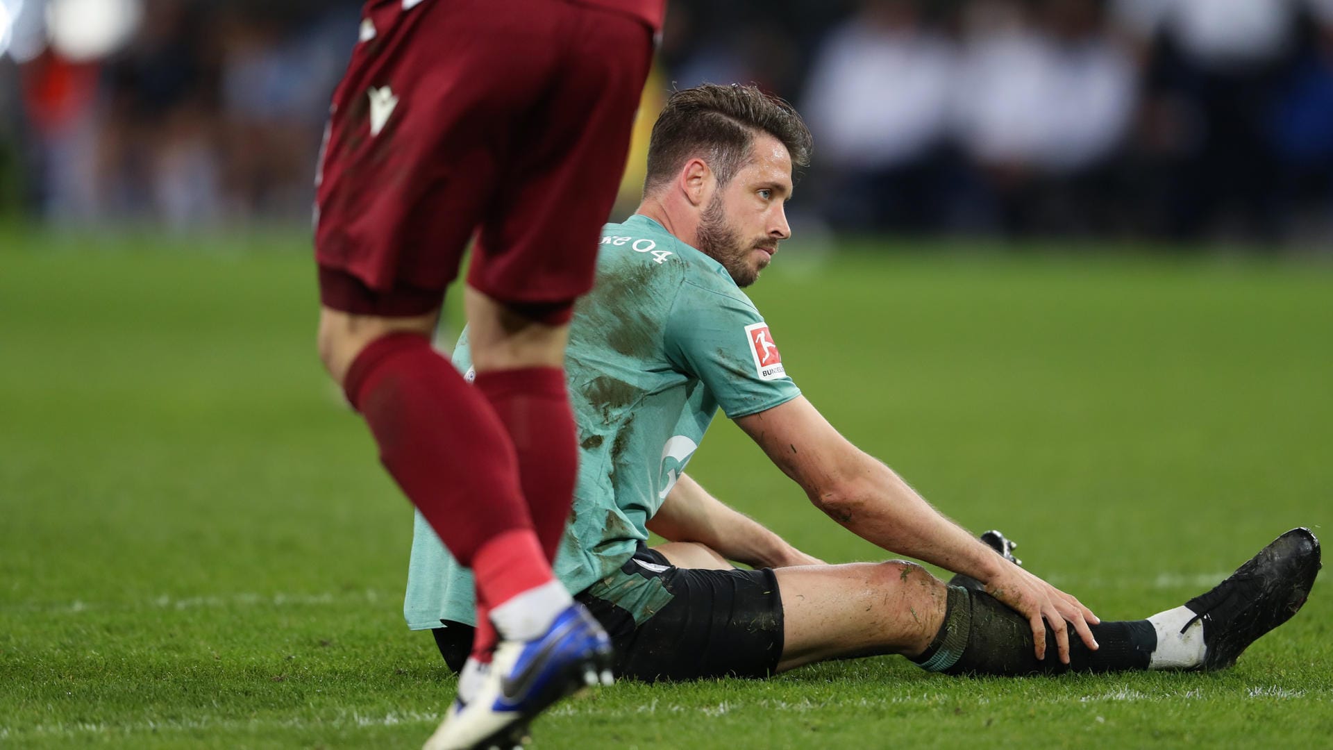 SchücoArena in Bielefeld: Schalkes Stürmer Mark Uth sitzt enttäuscht auf dem Rasen.