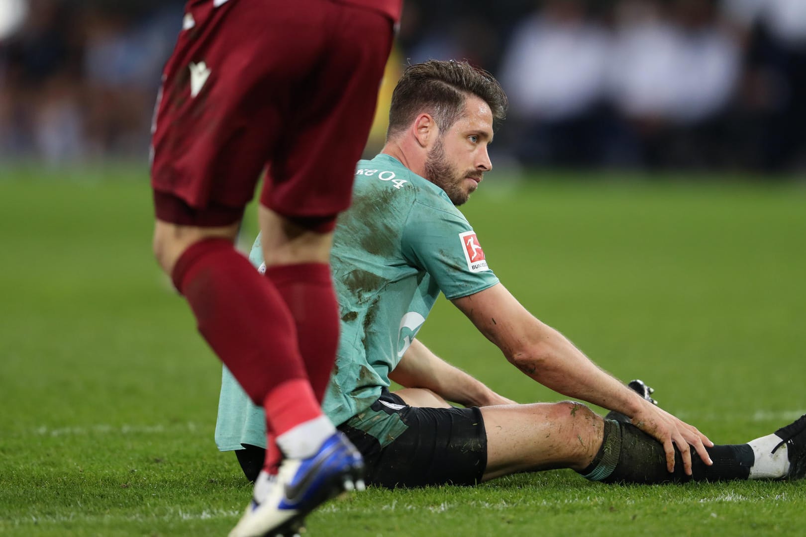 SchücoArena in Bielefeld: Schalkes Stürmer Mark Uth sitzt enttäuscht auf dem Rasen.