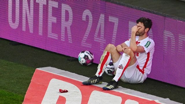 Jonas Hector vom FC Köln sitzt nach dem Spiel an einer Bande.