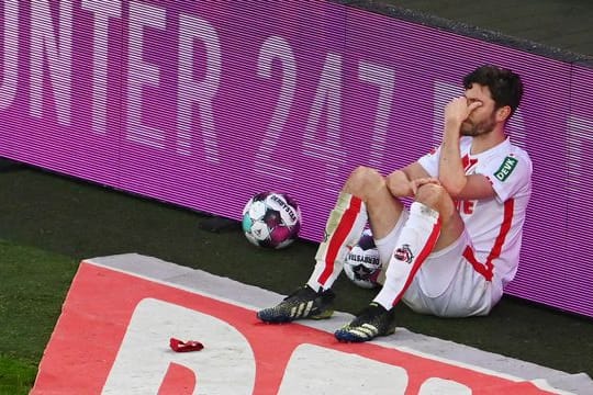 Jonas Hector vom FC Köln sitzt nach dem Spiel an einer Bande.